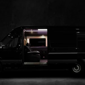 A black van with the door open at night.