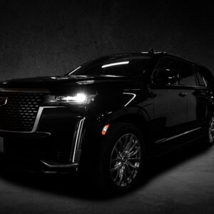 A black suv is parked in the dark.